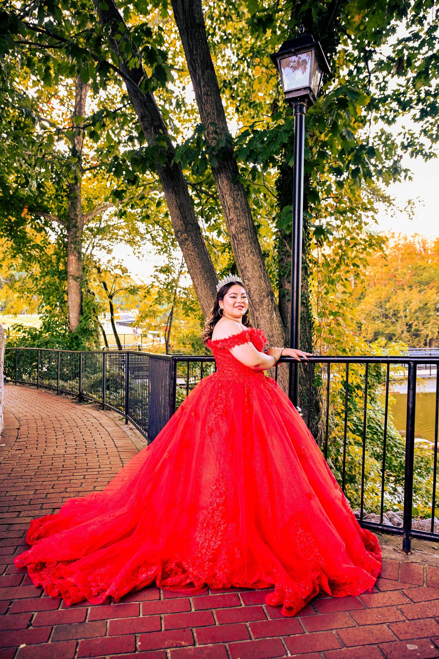 Quinceañera photoshoot featuring a stunning autumn red dress in an elegant portrait.