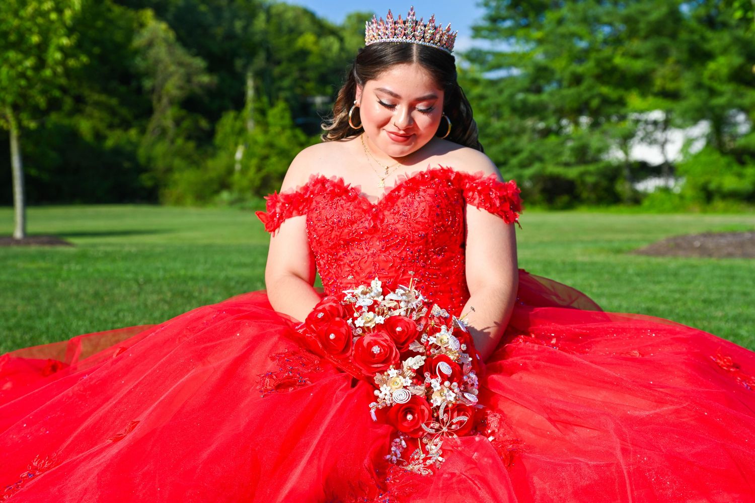 Elegant moment of the quinceañera looking down at her bouquet.