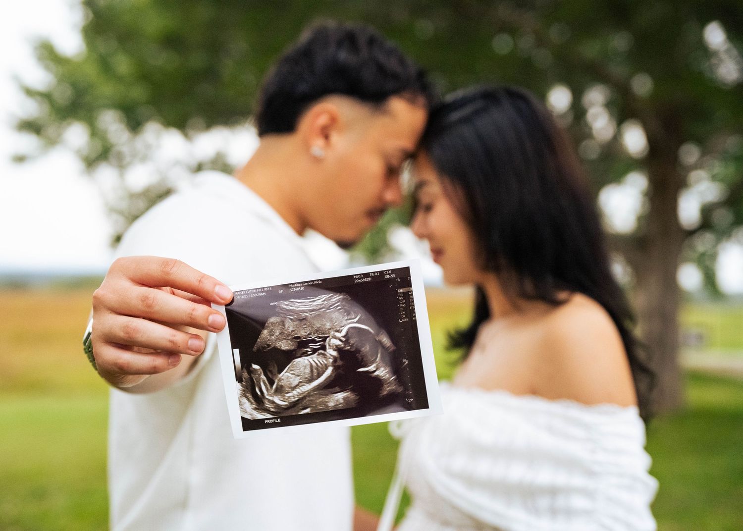 Sweet moments of couples holding their baby’s sonogram together in celebration of their growing family.