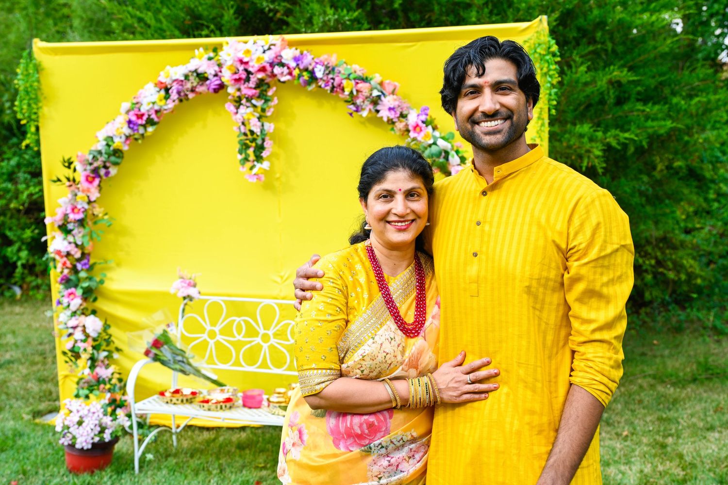 Mother and son smiling together during the joyful haldi ceremony.