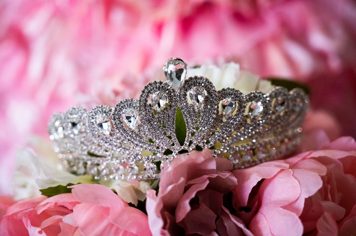 Elegant detail shot of the quinceañera crown resting on top of flowers.