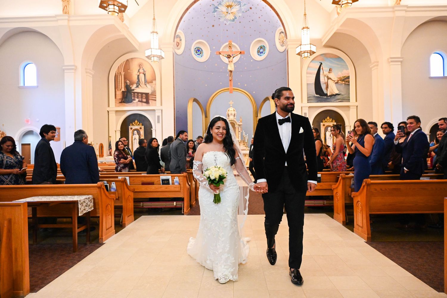 Couple walking out of the church with big smiles after their ceremony.