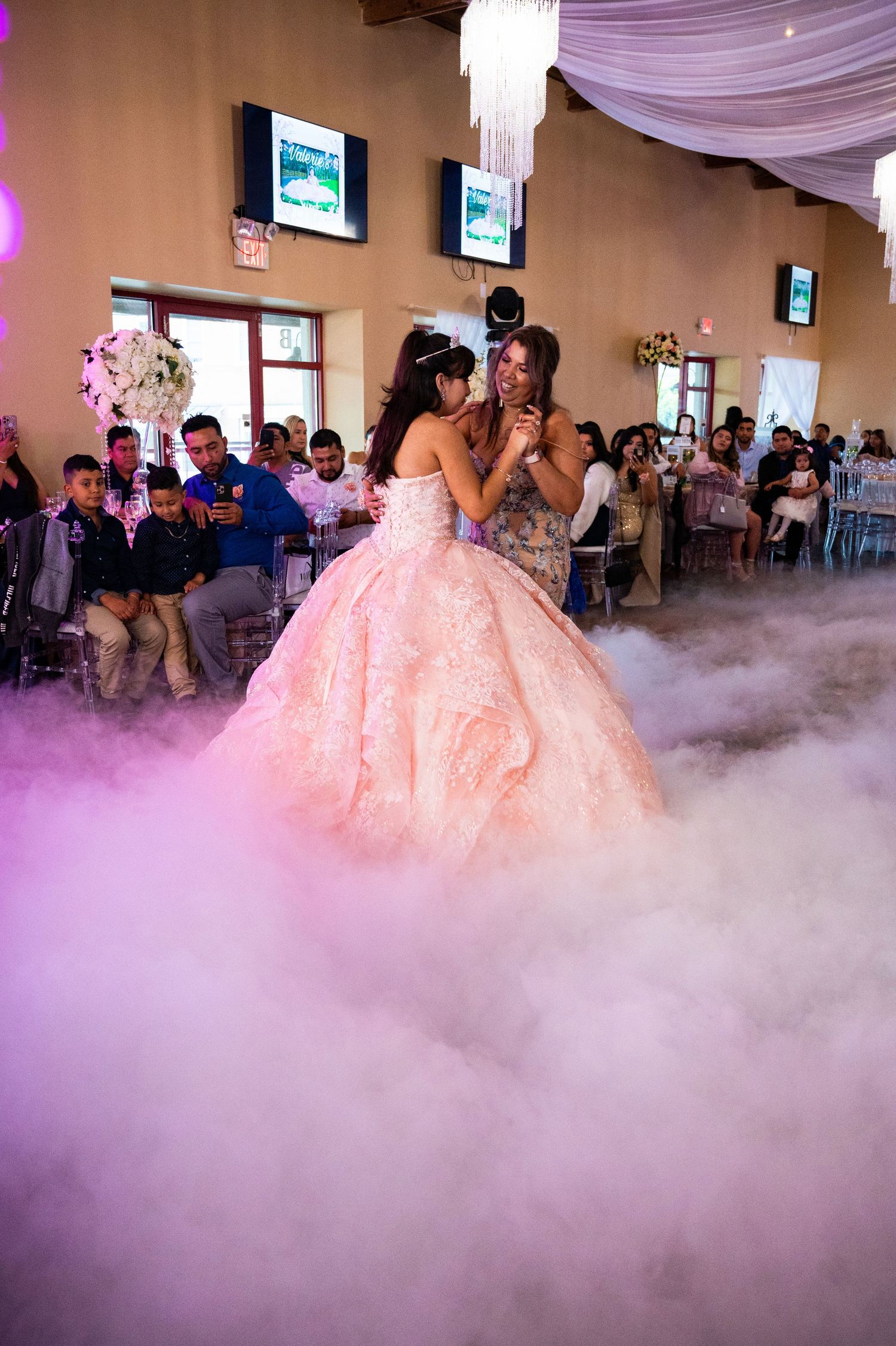 Magical mother and daughter dance surrounded by dreamy dry ice clouds on the dance floor.