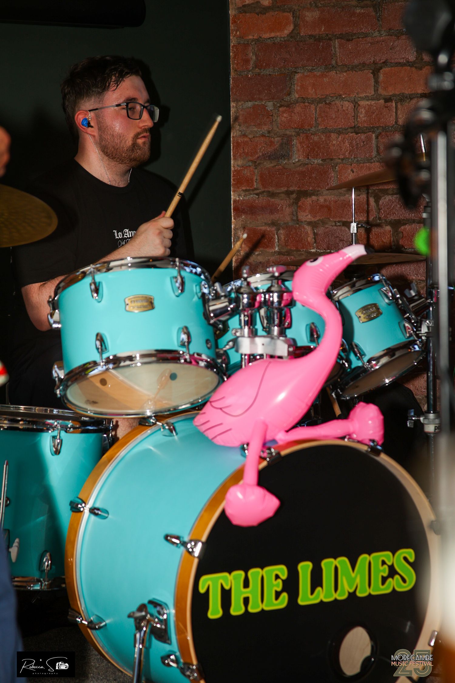 Turquoise drum kit with pink decorations and 'The Limes' text visible on stage.