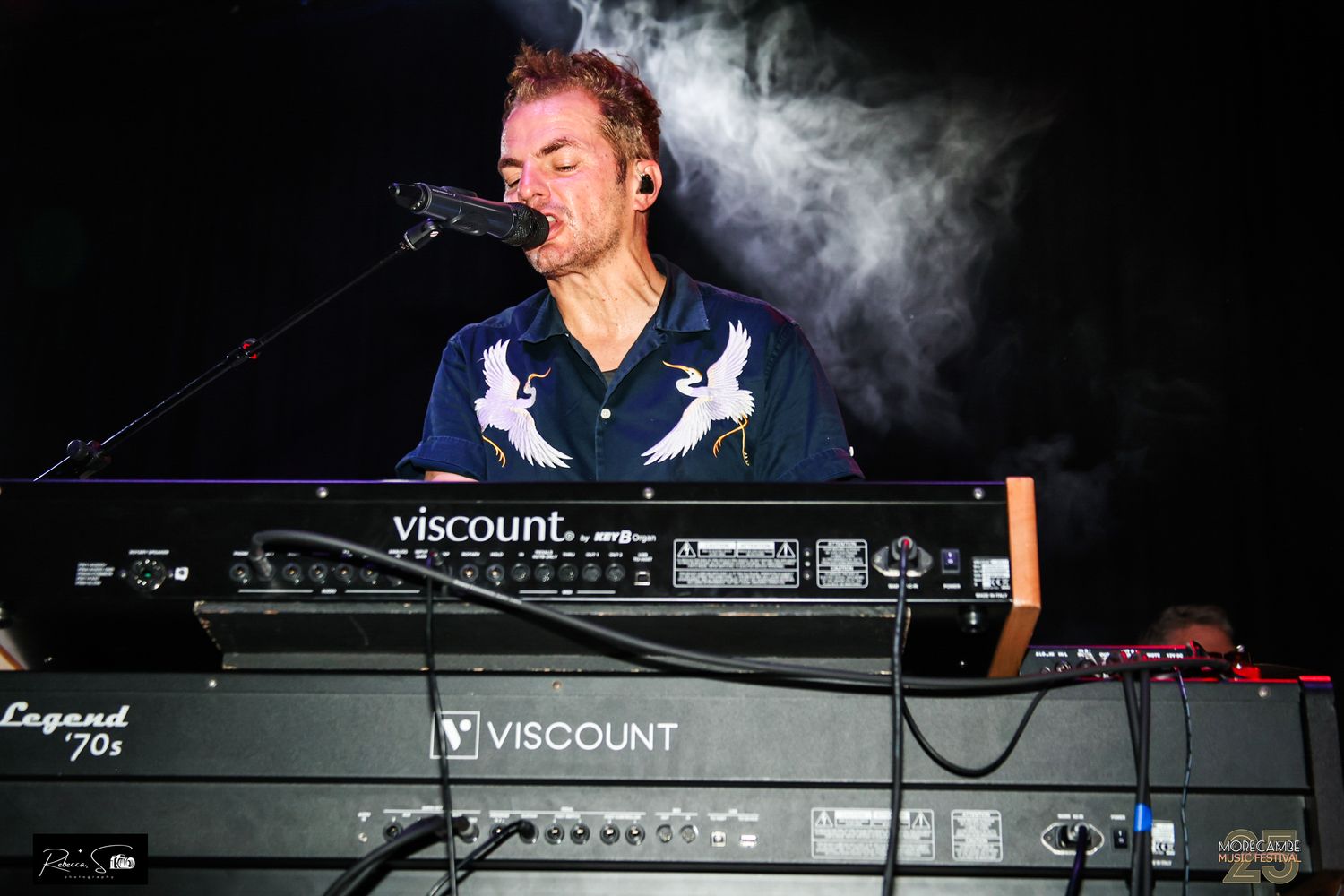 Keyboard player performs behind a Viscount electronic keyboard setup with atmospheric smoke effects.
