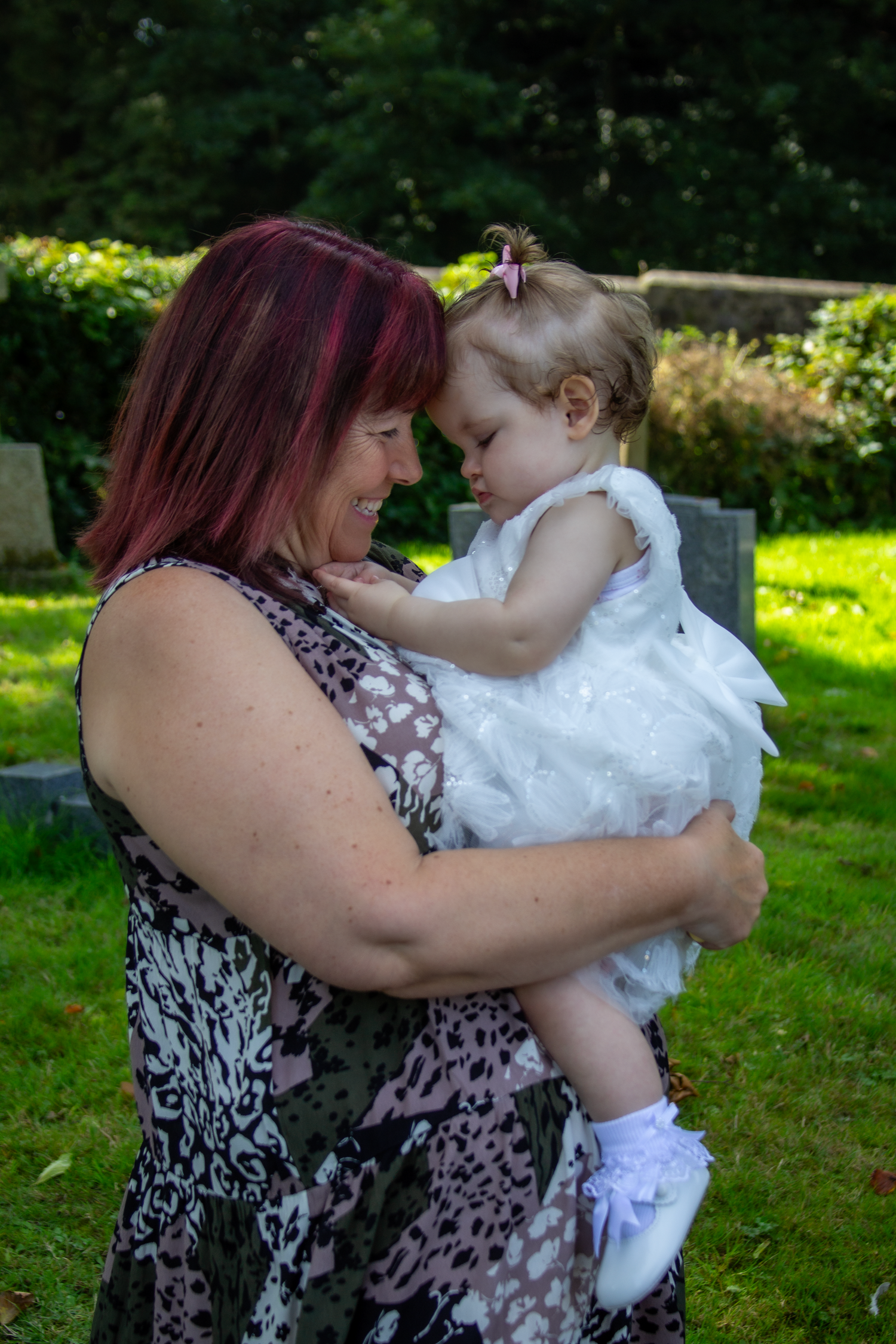 Tender moments shared between grandparent and child in a sunny garden setting.