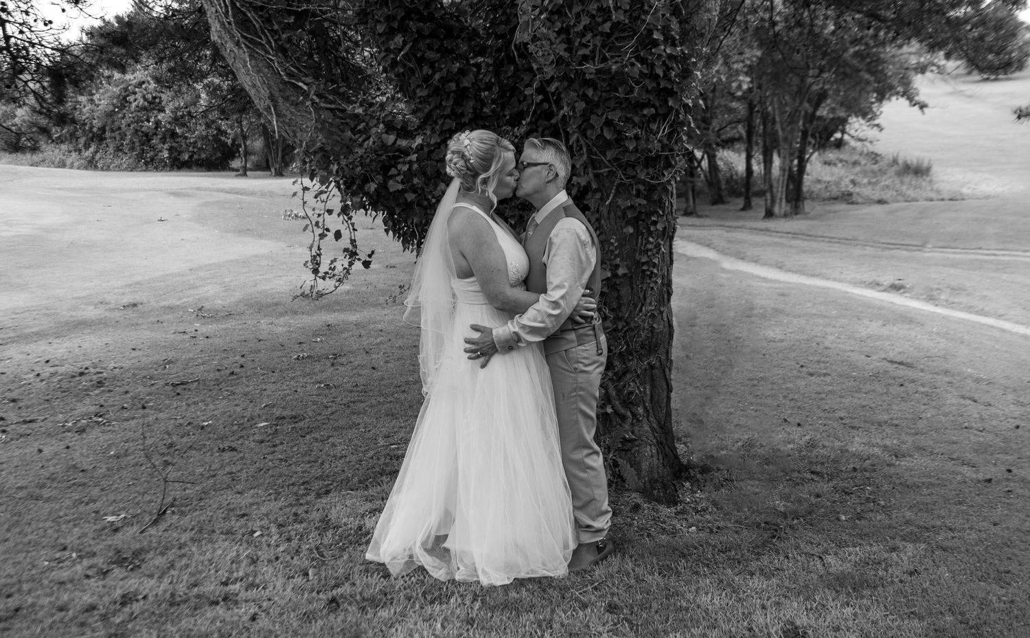 Black and white wedding photography in a scenic outdoor garden setting.