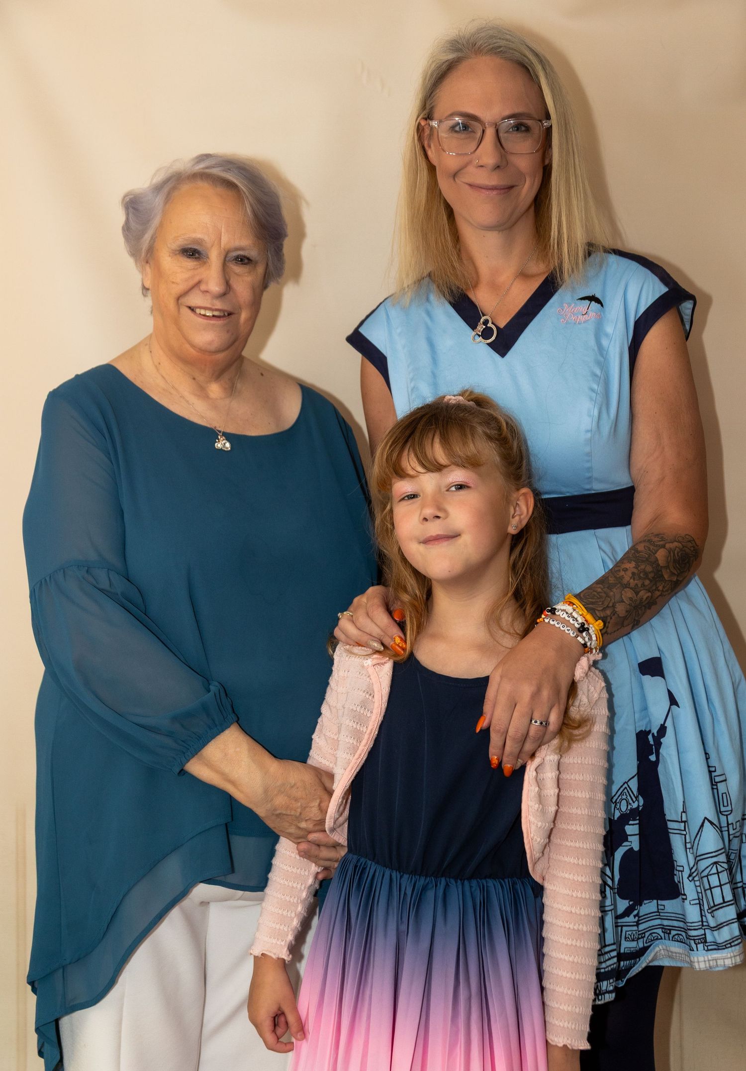 Family portrait session in coordinated blue outfits against a neutral background.