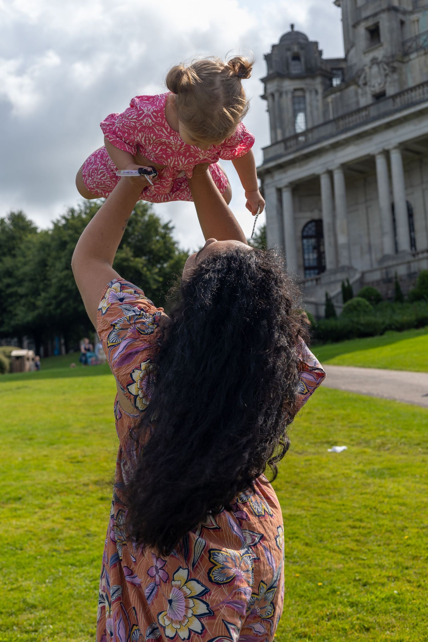 Playful dance poses captured in front of a grand historic building.