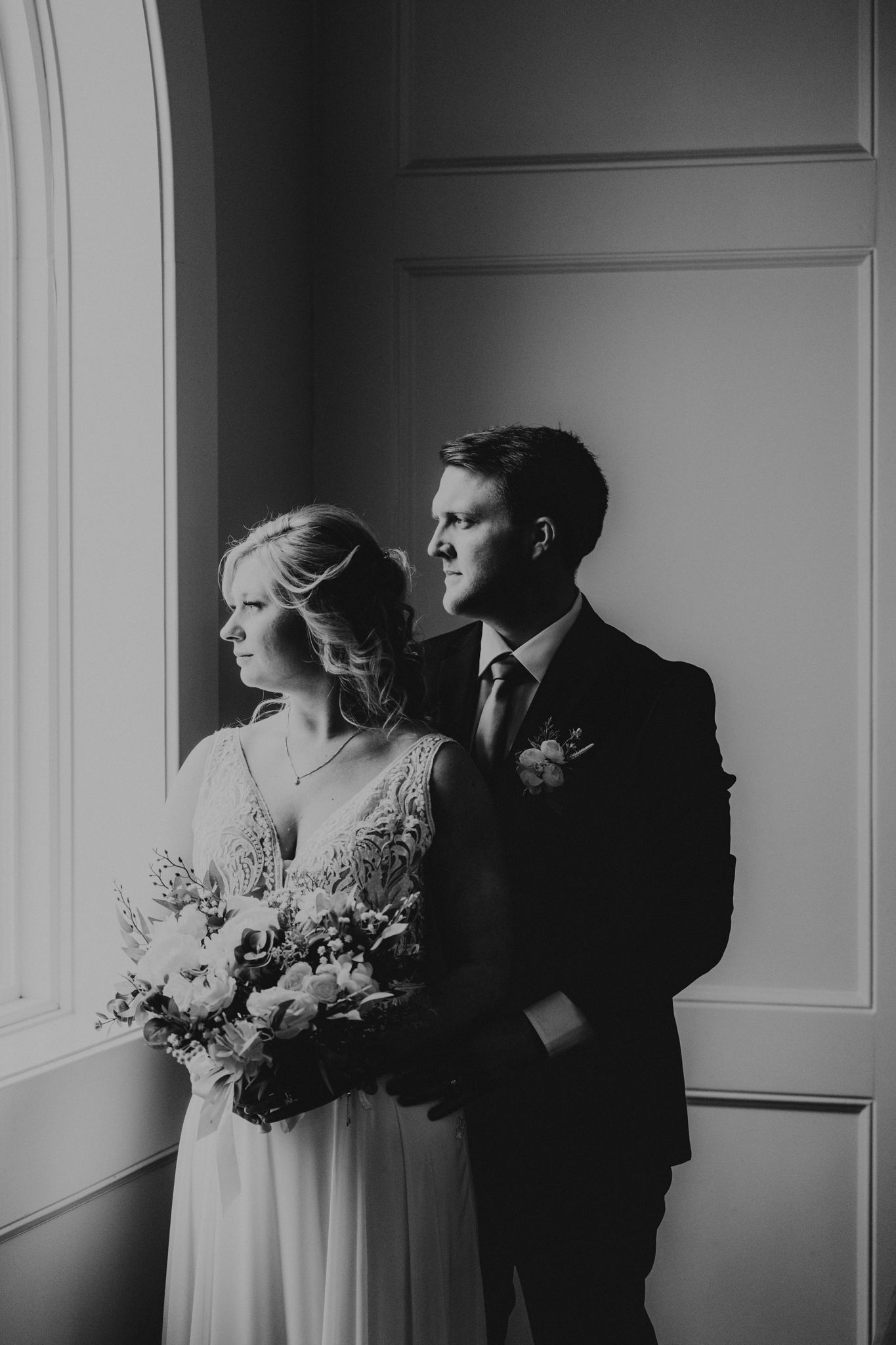 Dramatic black and white wedding portraits with natural window lighting.