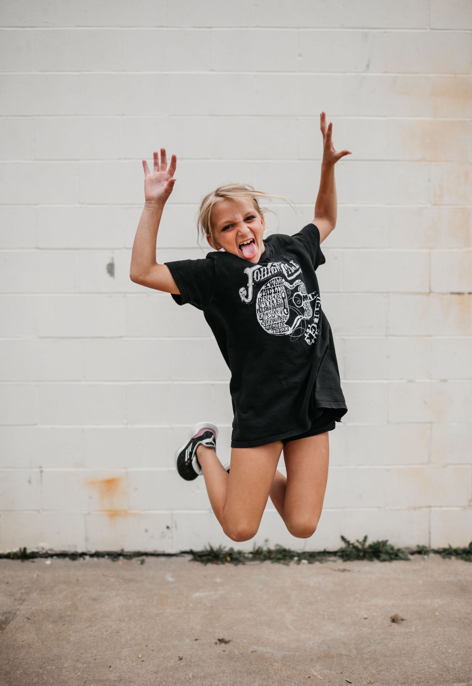 Sequential photos of a joyful jumping motion against a white wall.