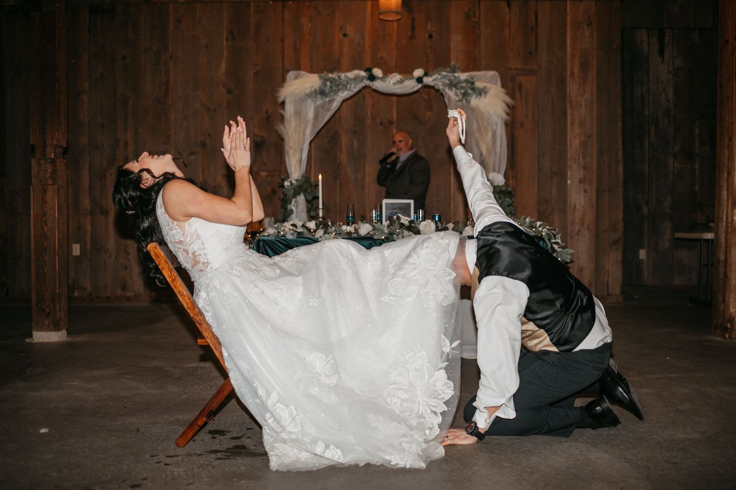 A couple performs a dip move on the dance floor during their wedding reception.