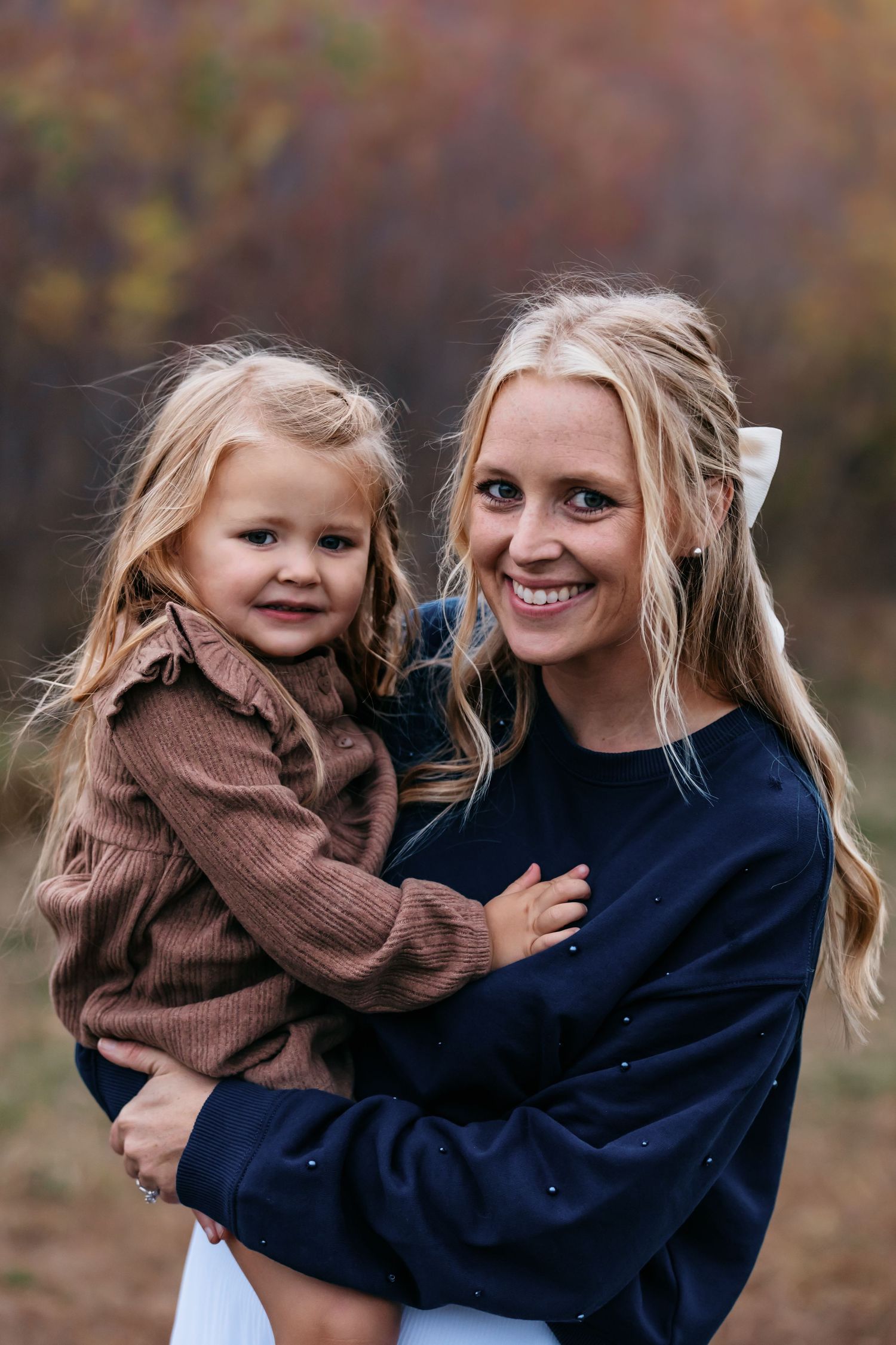 Playful autumn portraits capturing joyful moments between parent and child.
