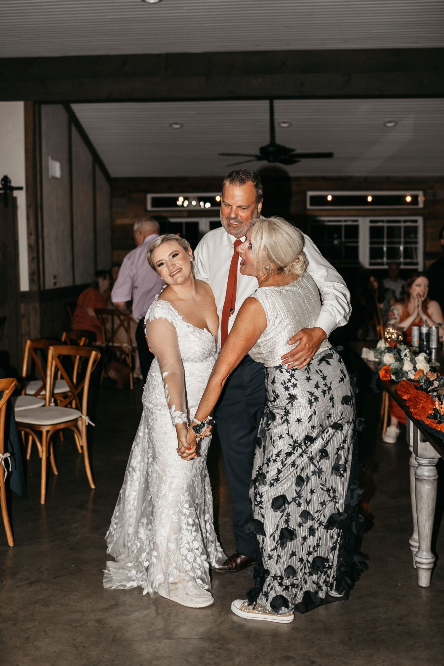 Wedding celebration with guests dancing in an elegant indoor venue.