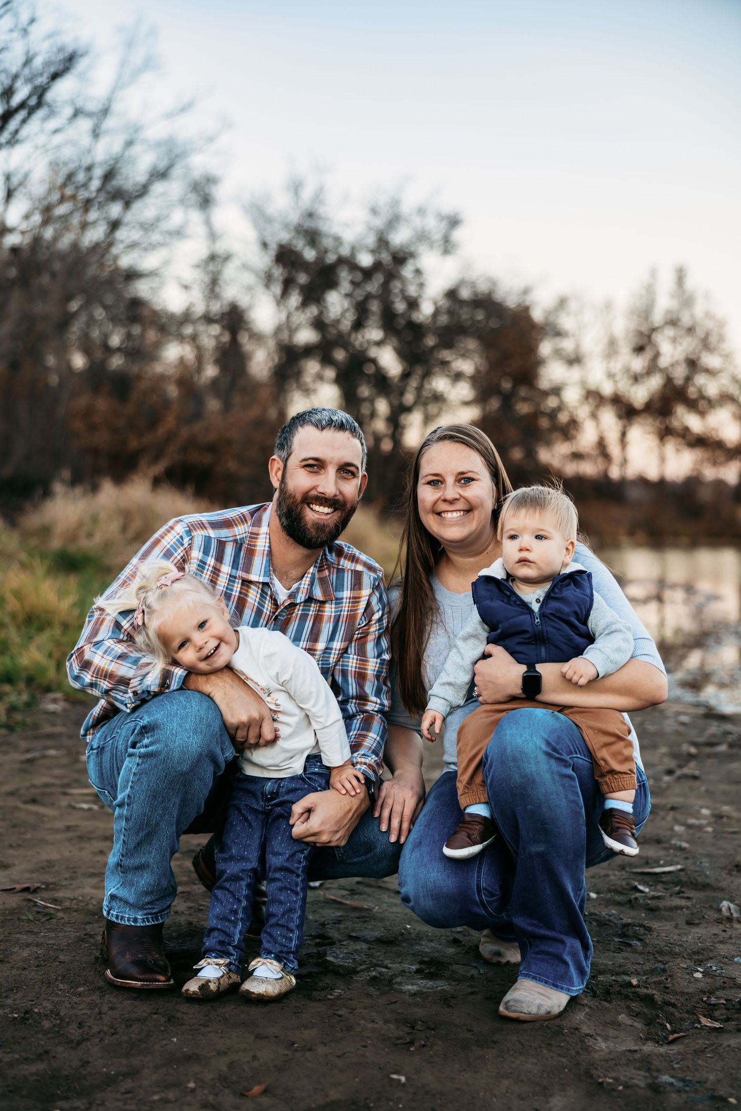 Family portrait session outdoors with casual clothing and natural expressions.