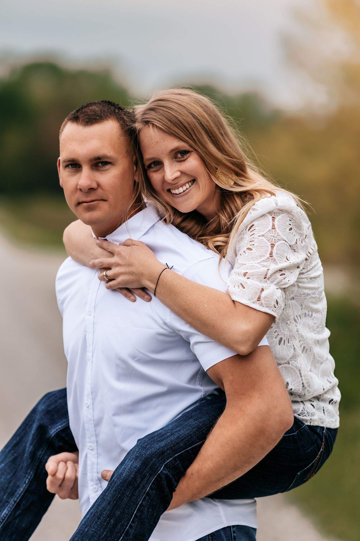 Playful couple embracing and laughing together during outdoor photo session.