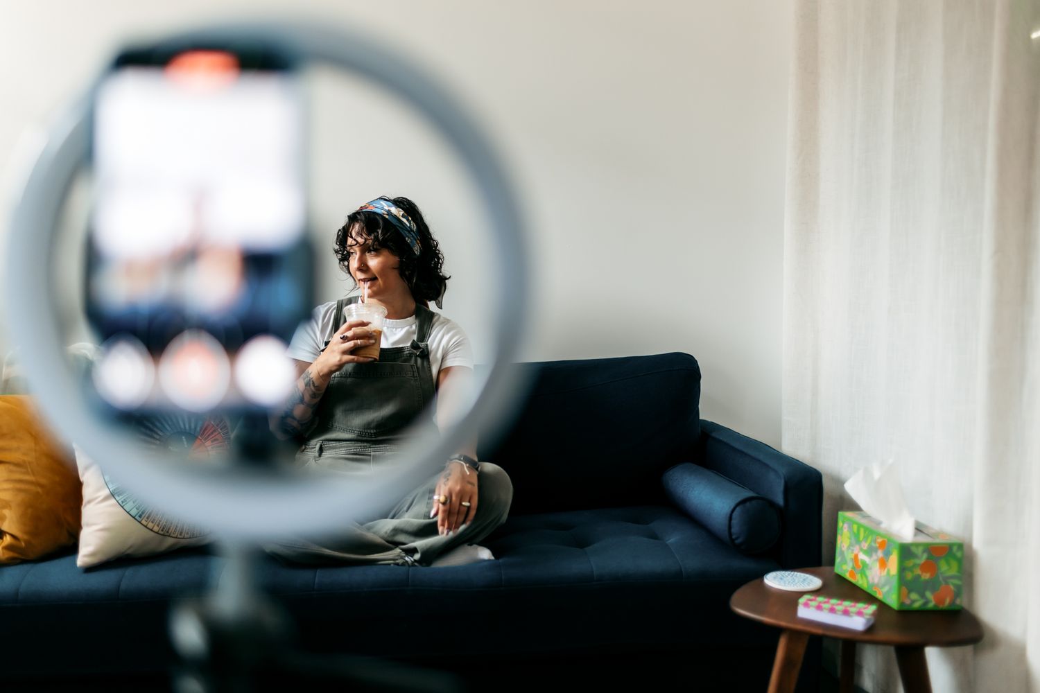 Reflection through a circular ring light showing a cozy living room scene.
