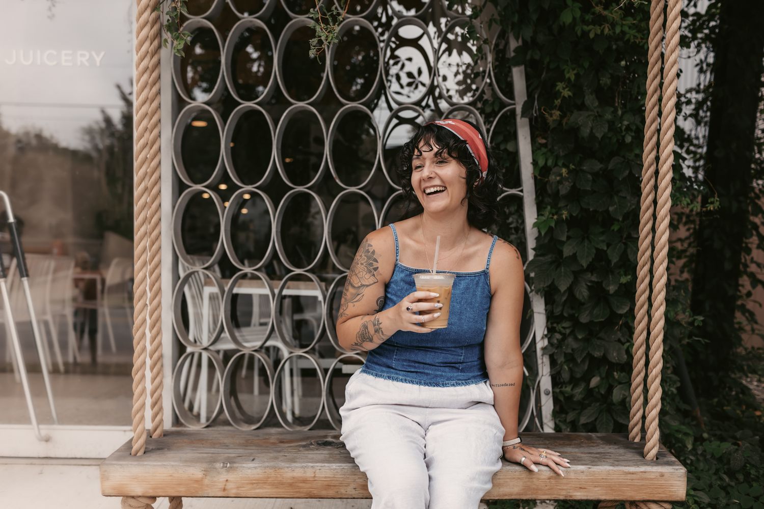 A relaxed outdoor scene with a beverage and decorative metal wall backdrop.