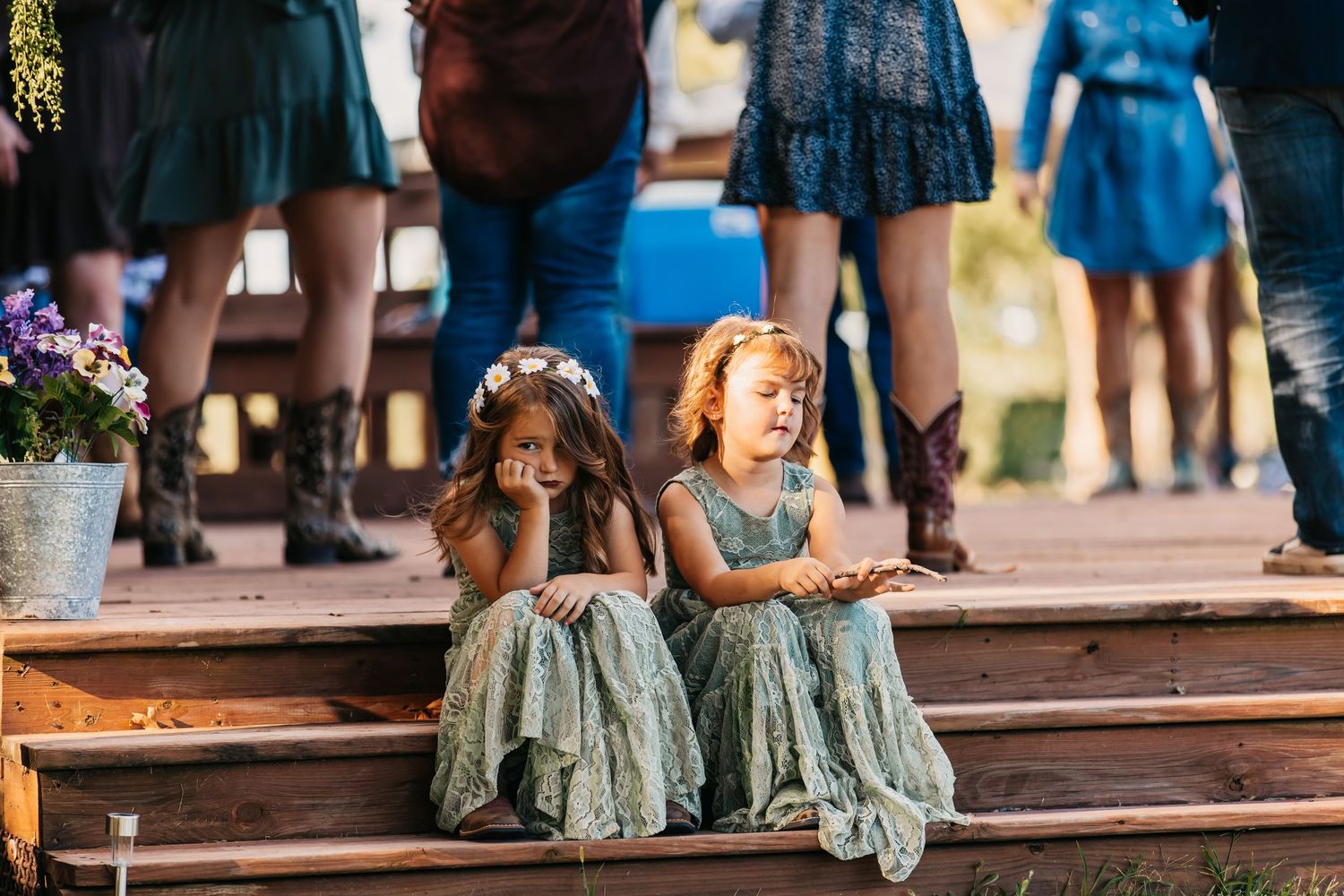 Wedding guests' feet showing coordinated blue and green footwear on wooden steps.