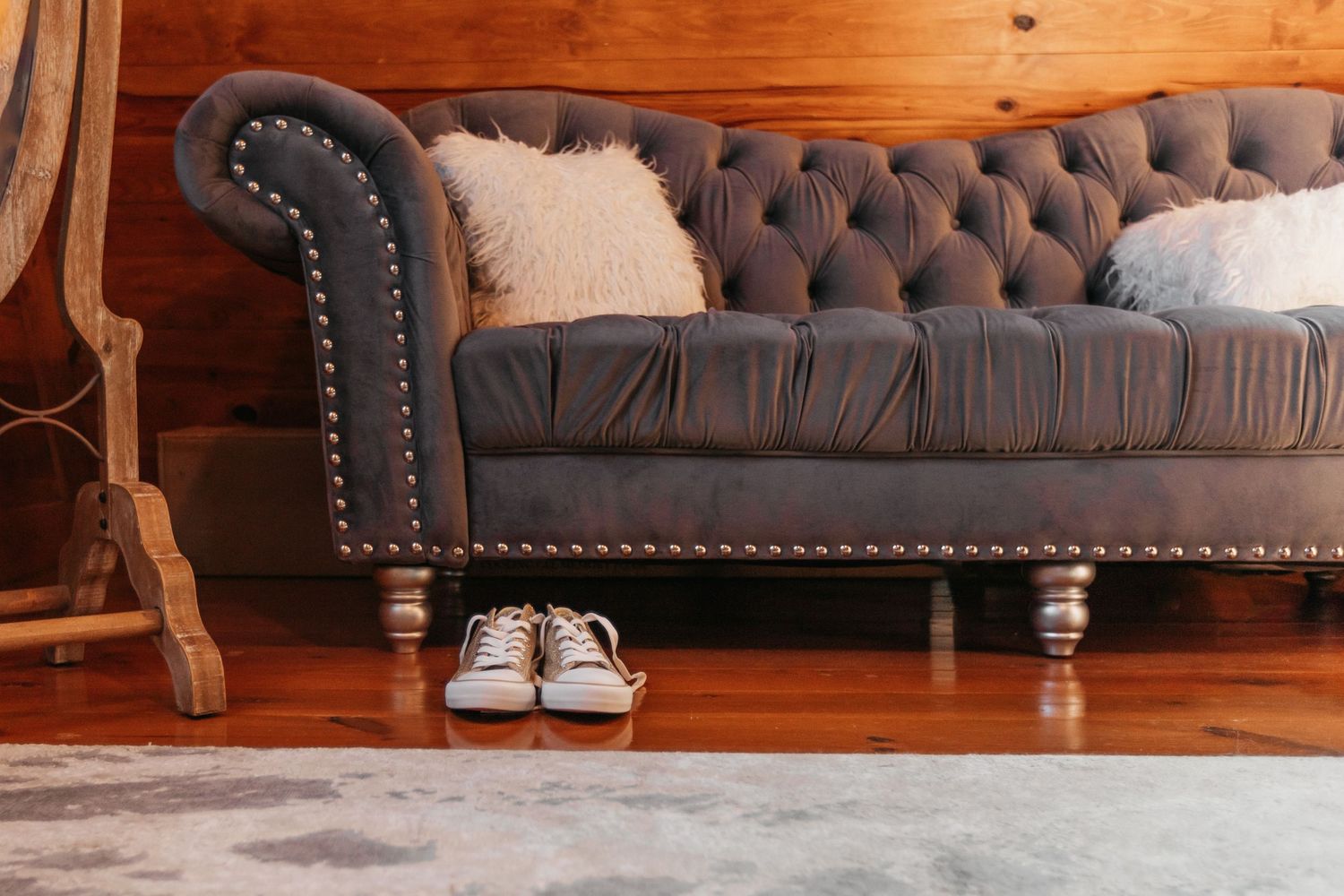 Brown leather tufted couch detail in rustic indoor setting.