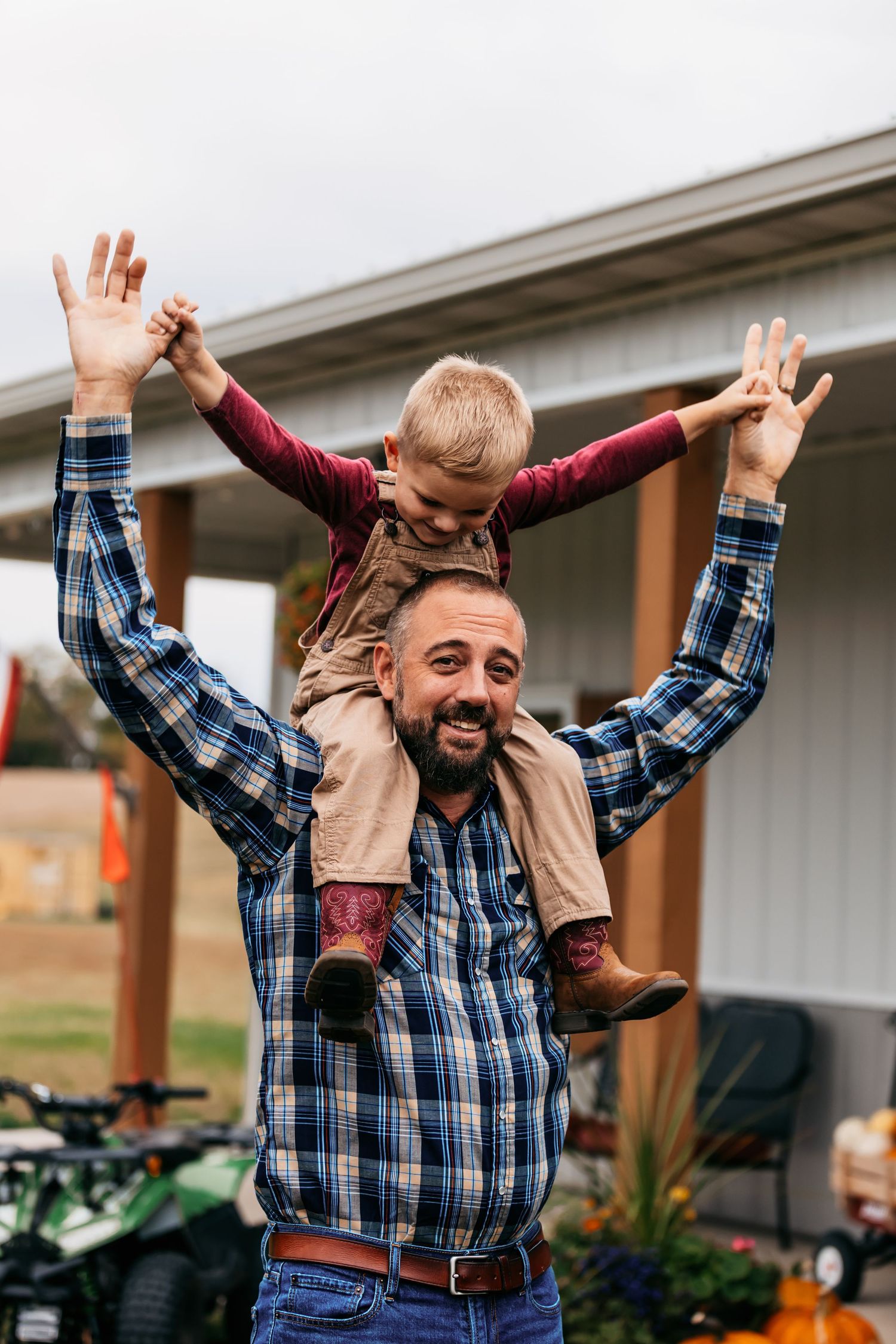 Playful sequence of someone jumping and celebrating in a plaid shirt and vest outdoors.