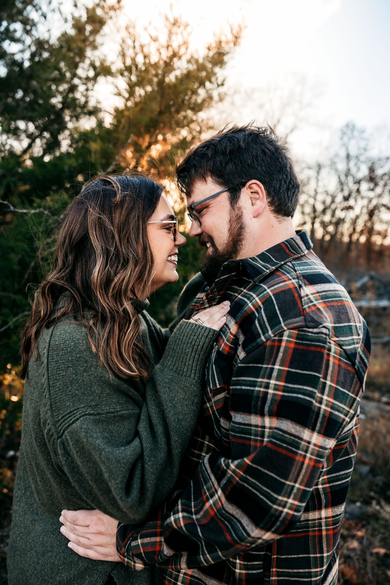 Romantic couple in cozy sweaters sharing intimate moment at sunset.
