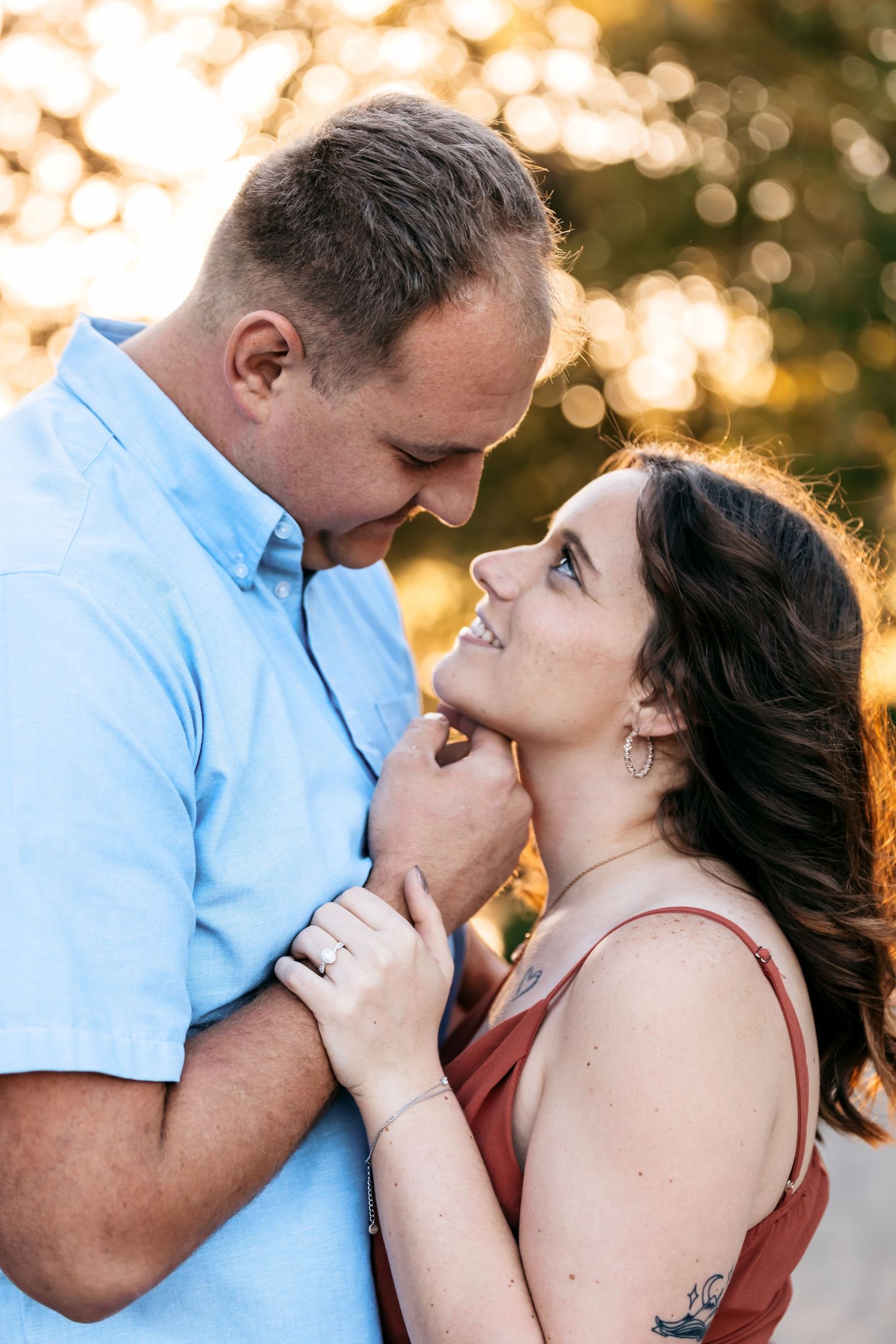 A romantic couple shares intimate moments during a golden hour photoshoot.