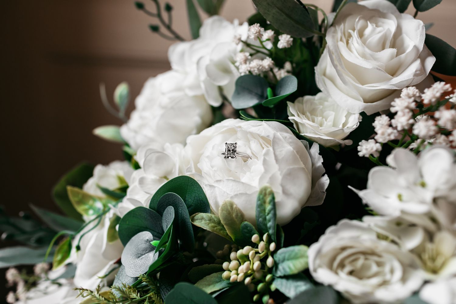 Close-up of white roses and delicate floral arrangements with greenery.