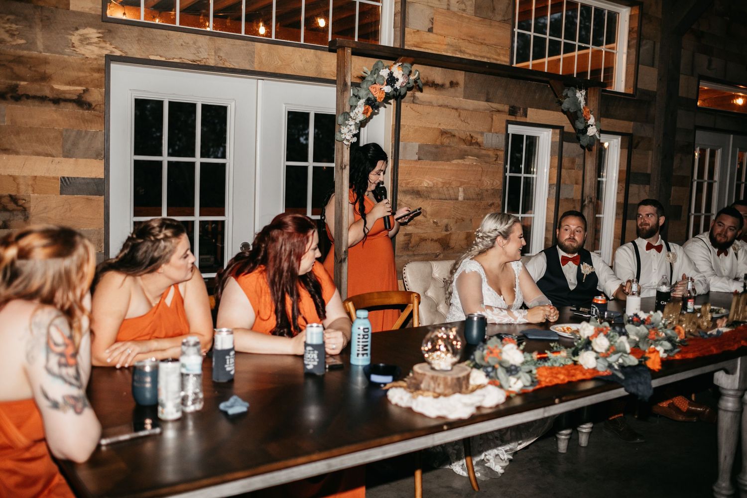 Wedding reception venue with rustic wooden walls and warm lighting.