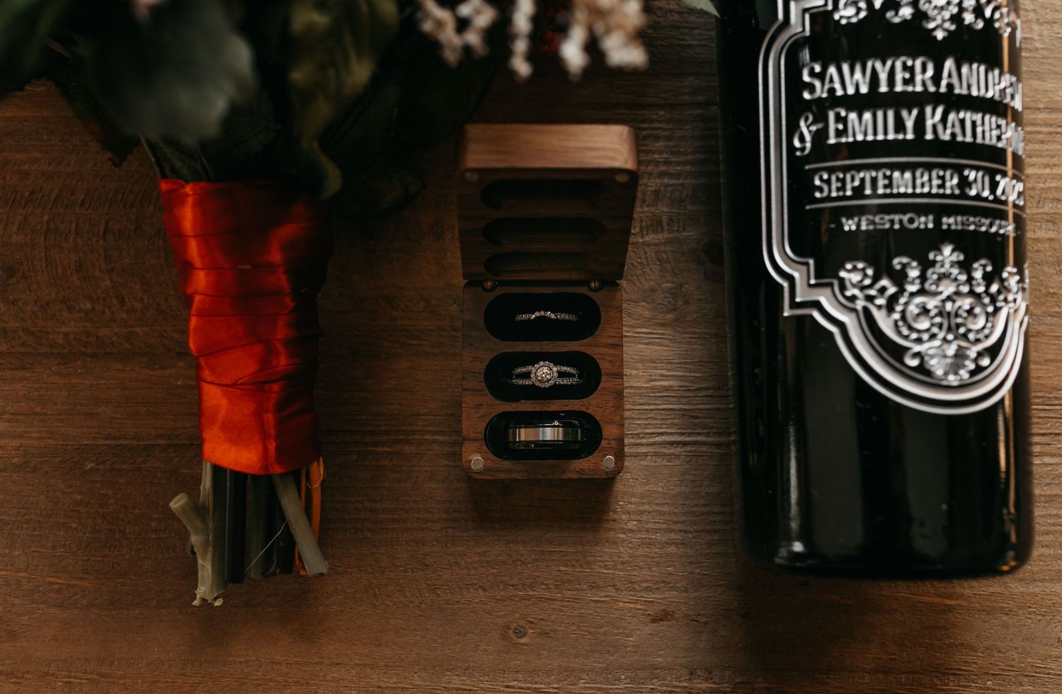 Mason jars with custom wedding labels line a rustic wooden shelf.