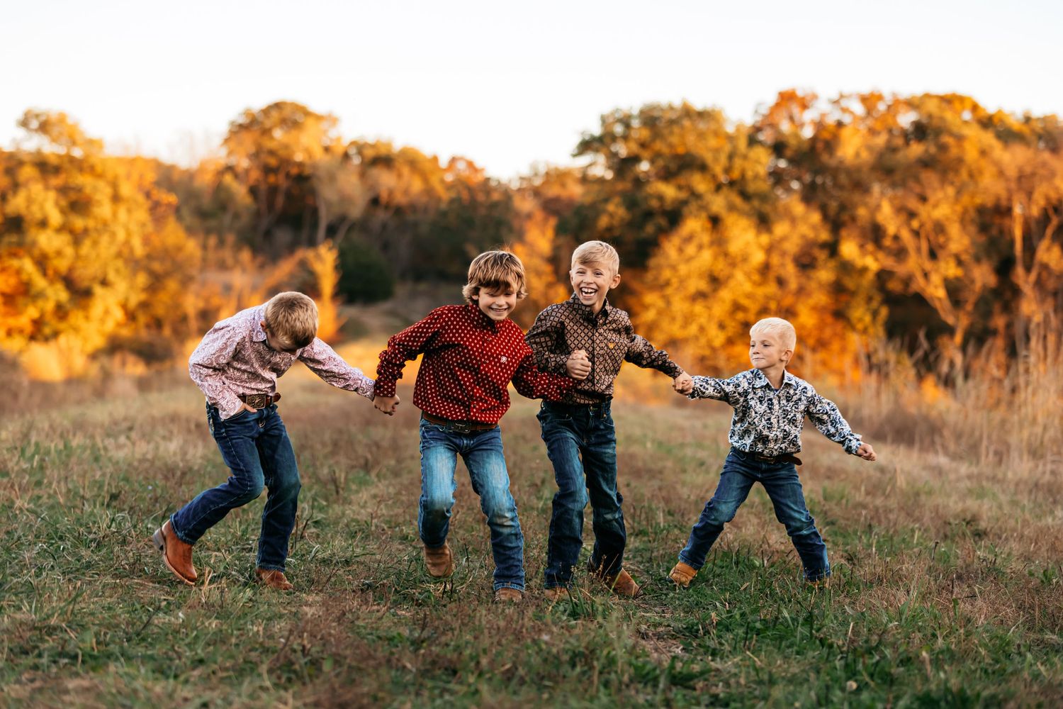 A playful family photoshoot in a golden autumn field during sunset in Missouri