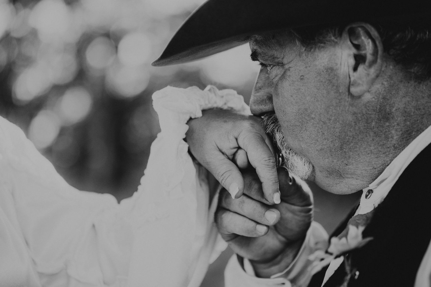 Black and white close-up of tender moment between couple during wedding ceremony.