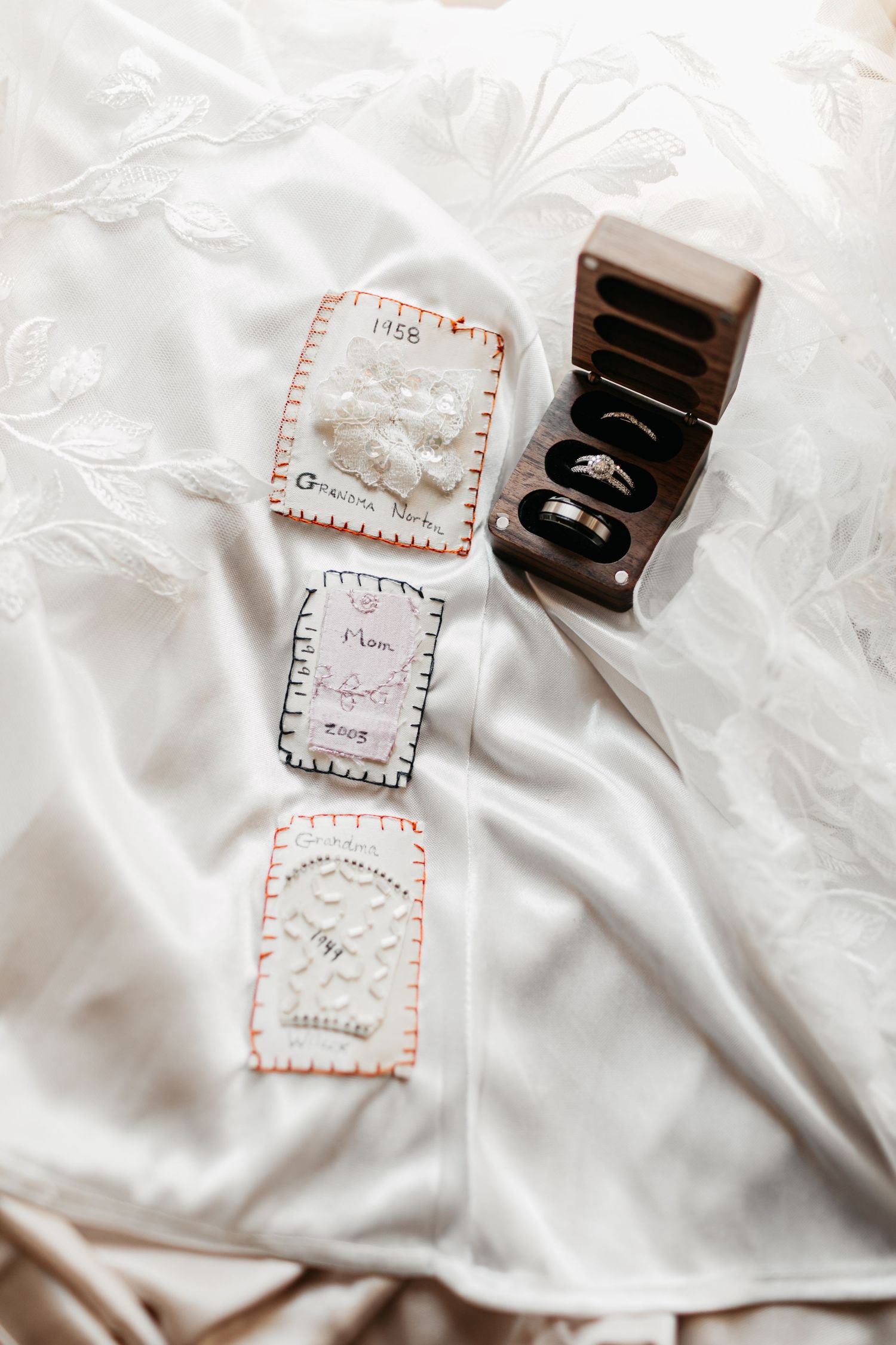 Wedding rings and handwritten notes displayed on white fabric.