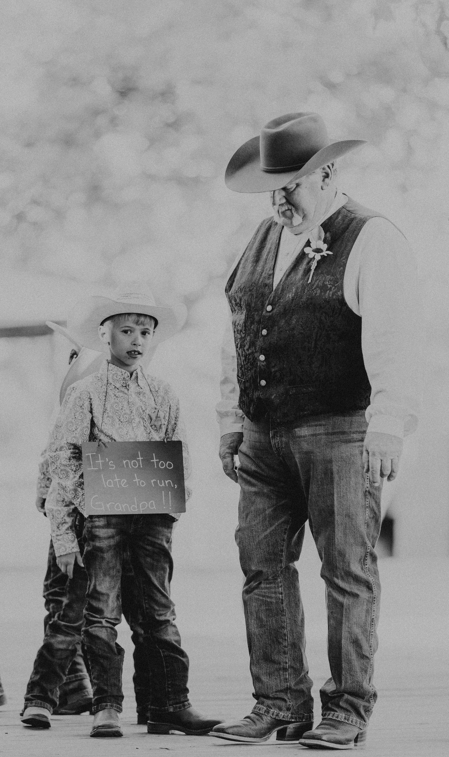 Vintage black and white photograph showing only legs wearing jeans and boots standing in a row.