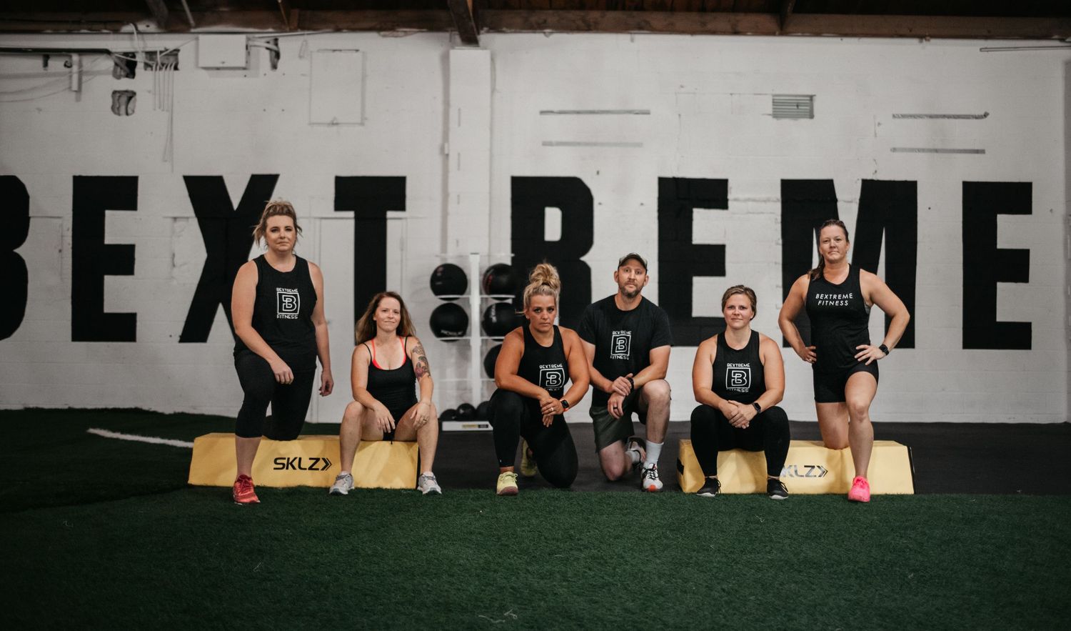 Group workout session in a spacious fitness facility with white brick walls.