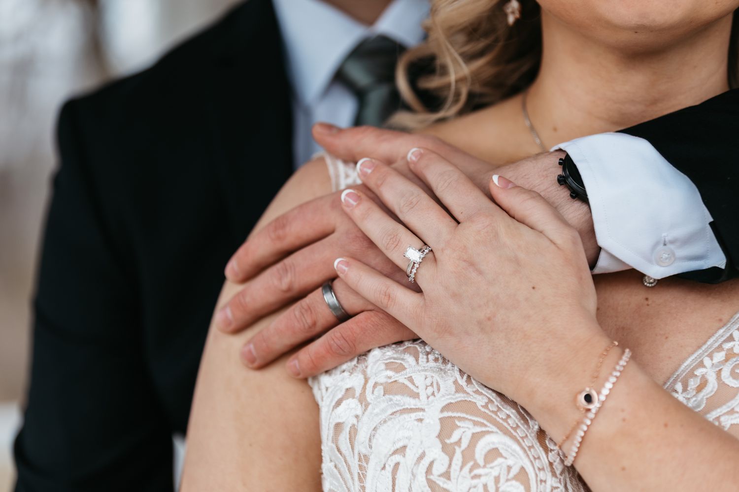 Close-up details of wedding attire and romantic embrace.