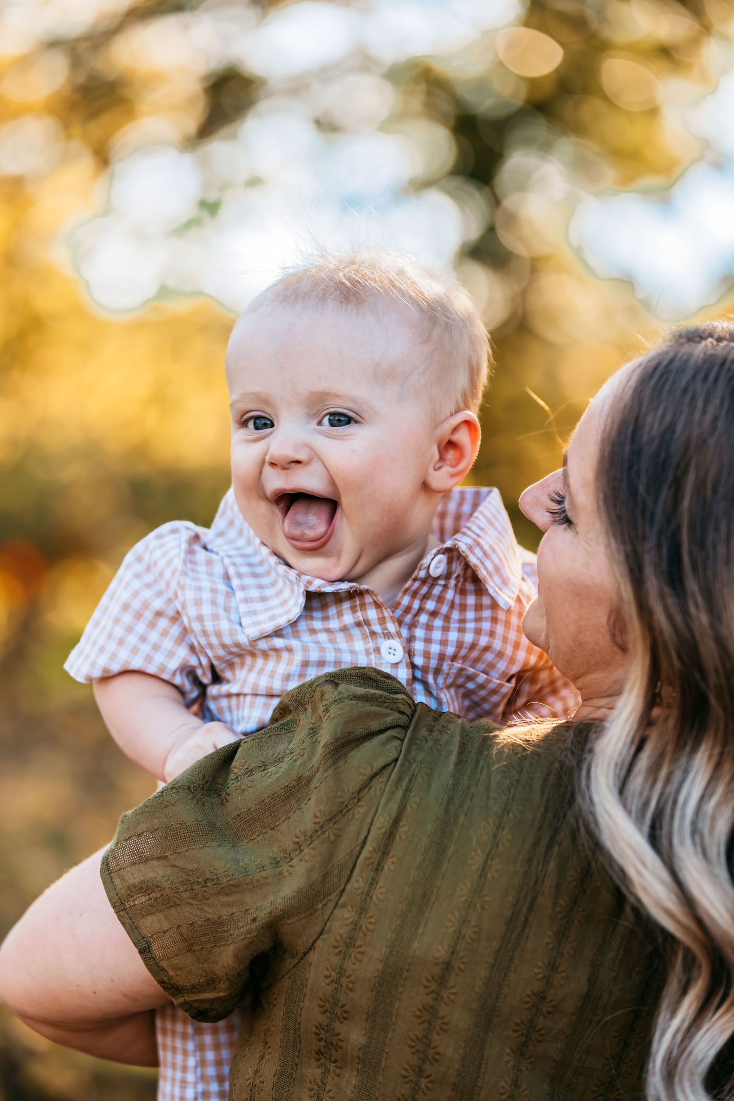 Sweet moment between parent and baby outdoors during golden hour.