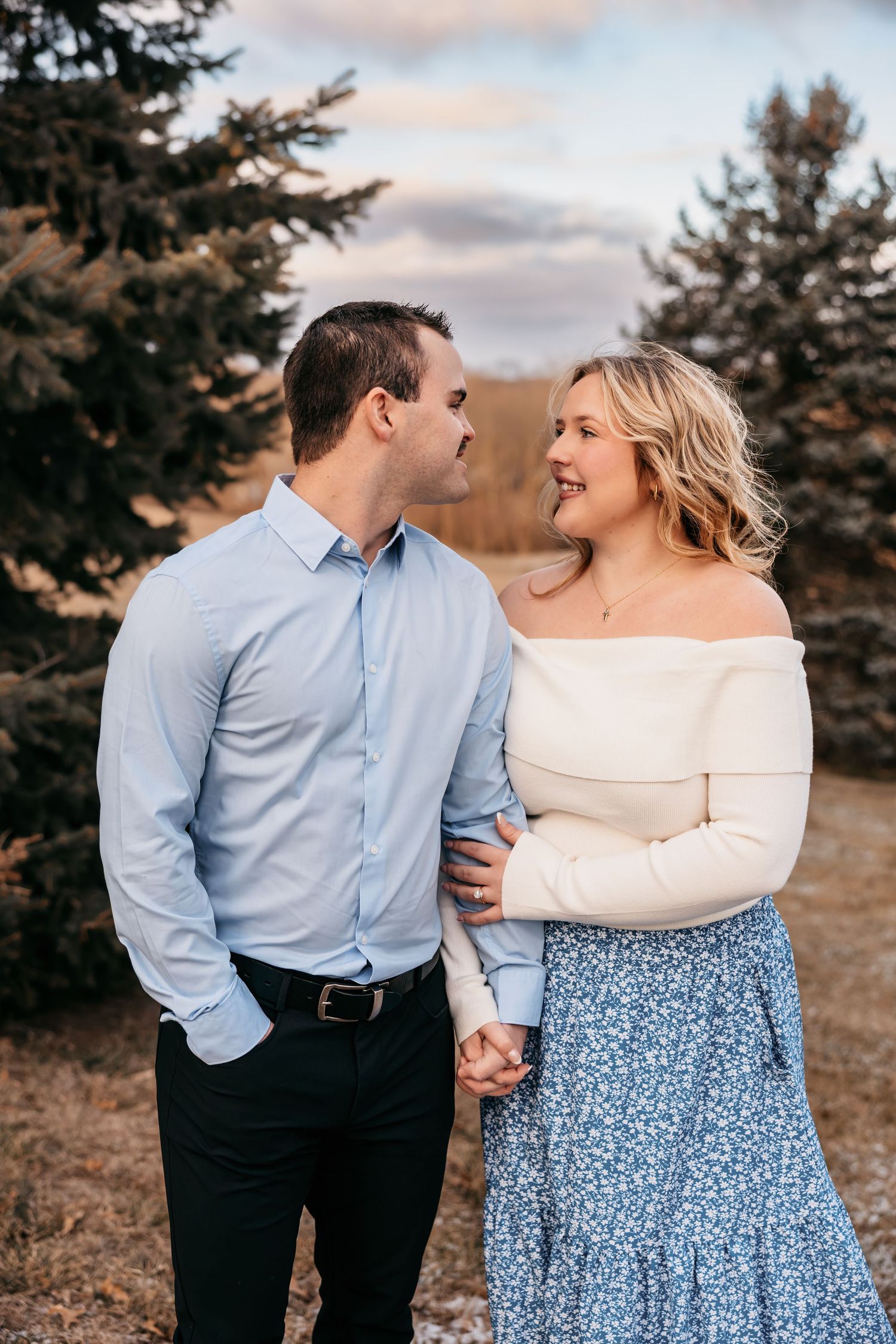 Romantic couple portrait series in coordinating blue and white outfits against an autumn landscape.