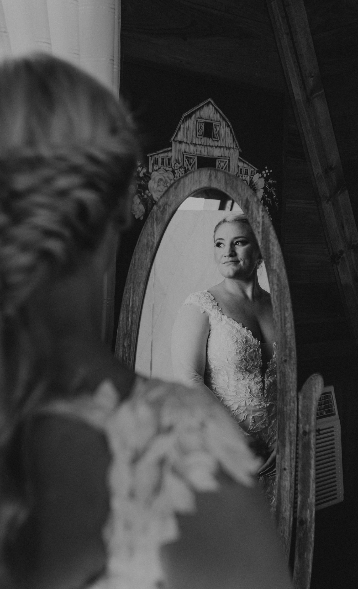 Artistic black and white bridal portrait reflected in vintage mirror.