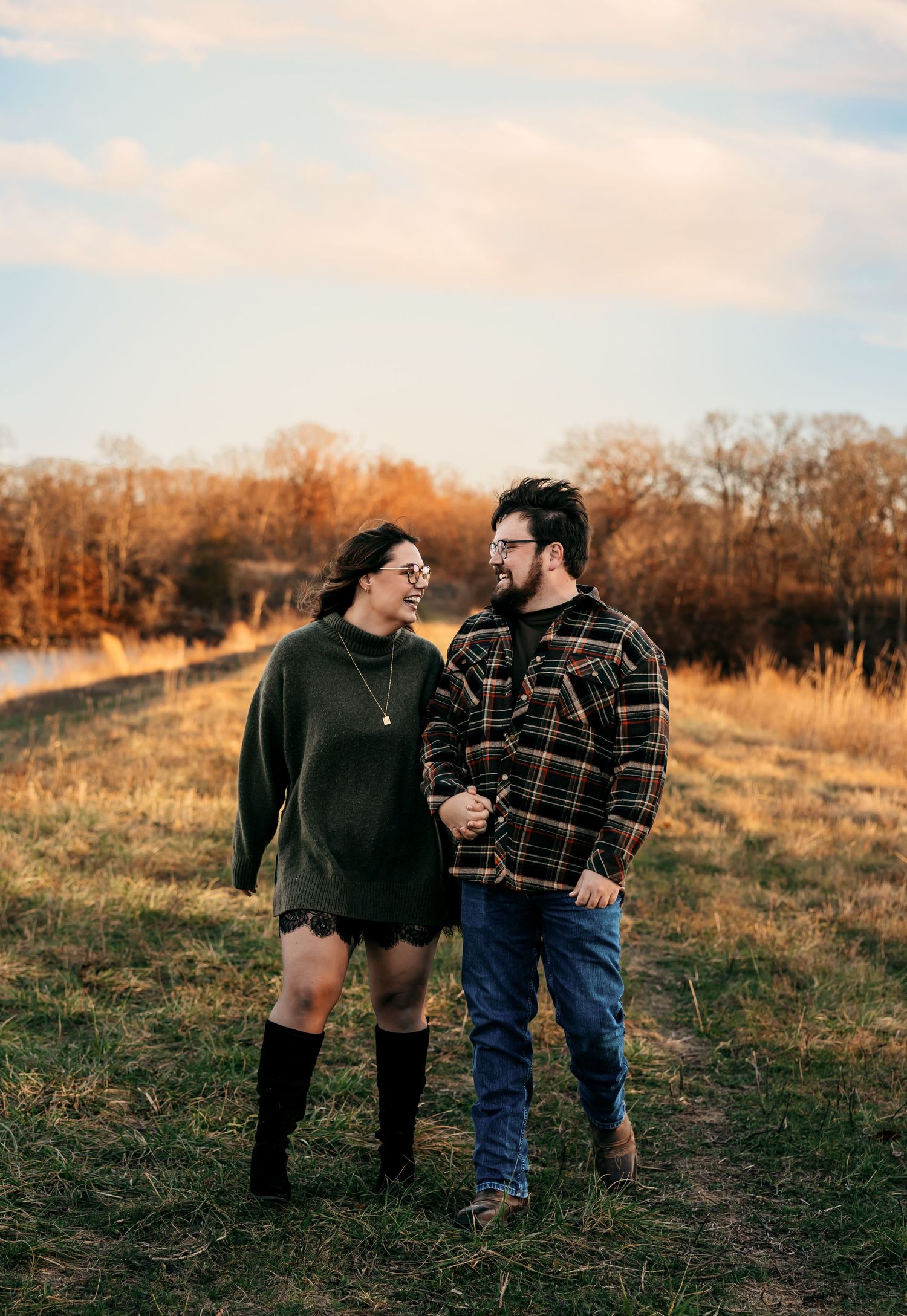 Candid couple photos in casual fall attire walking and laughing together on a golden hillside.