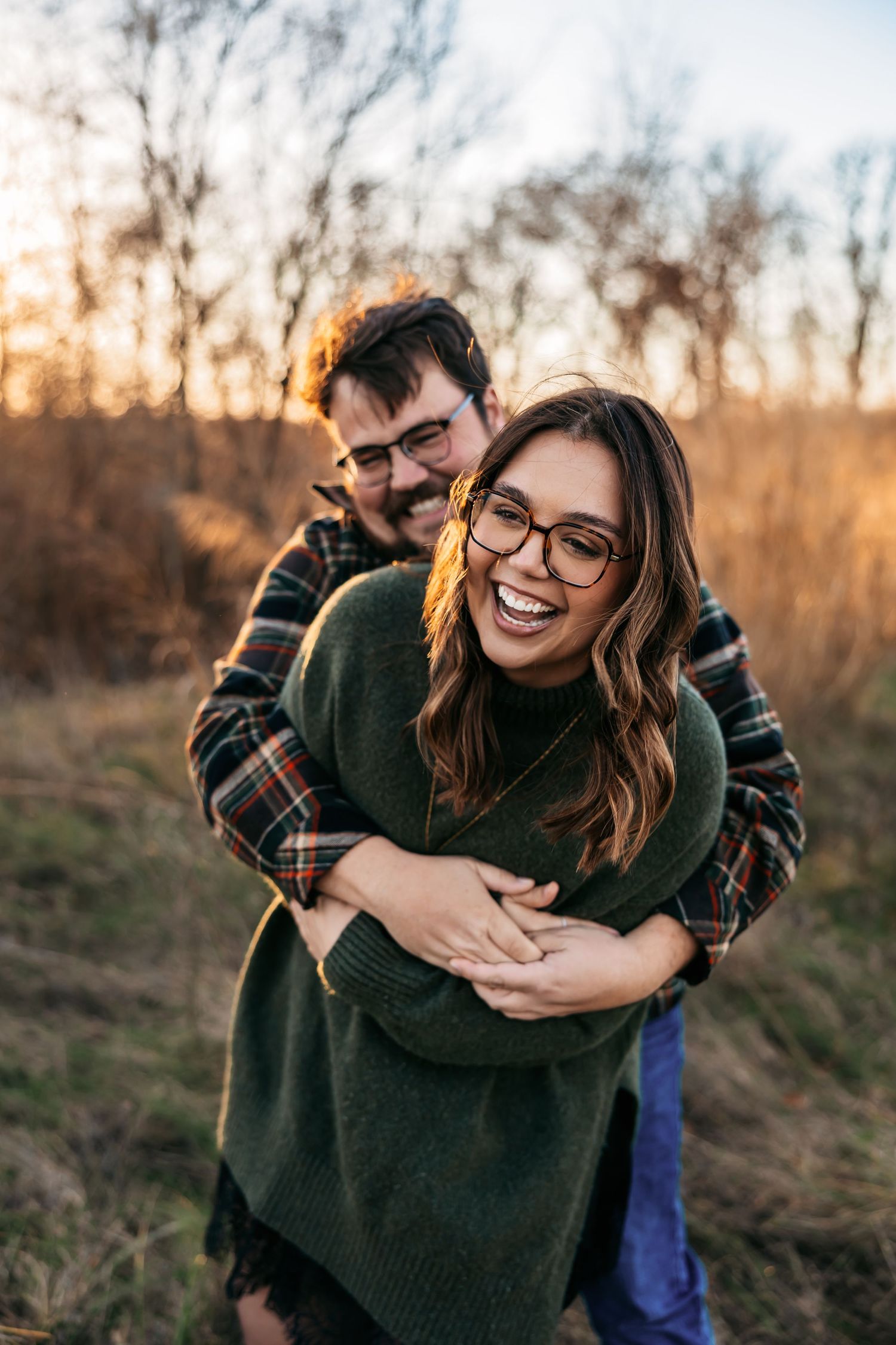 Couple sharing a joyful embrace outdoors during golden hour.