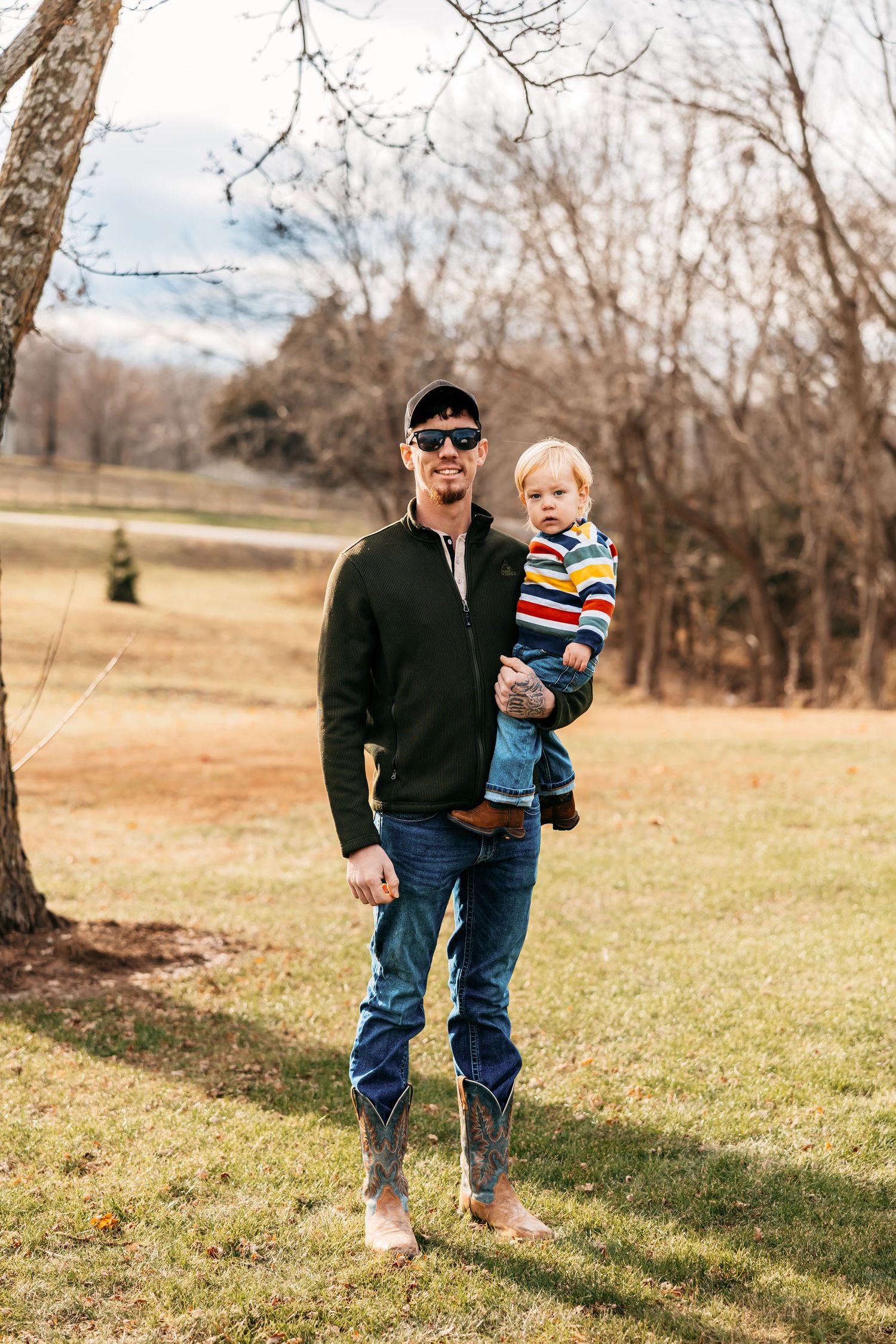 Candid outdoor family photos showing people walking together in a grassy field during autumn.
