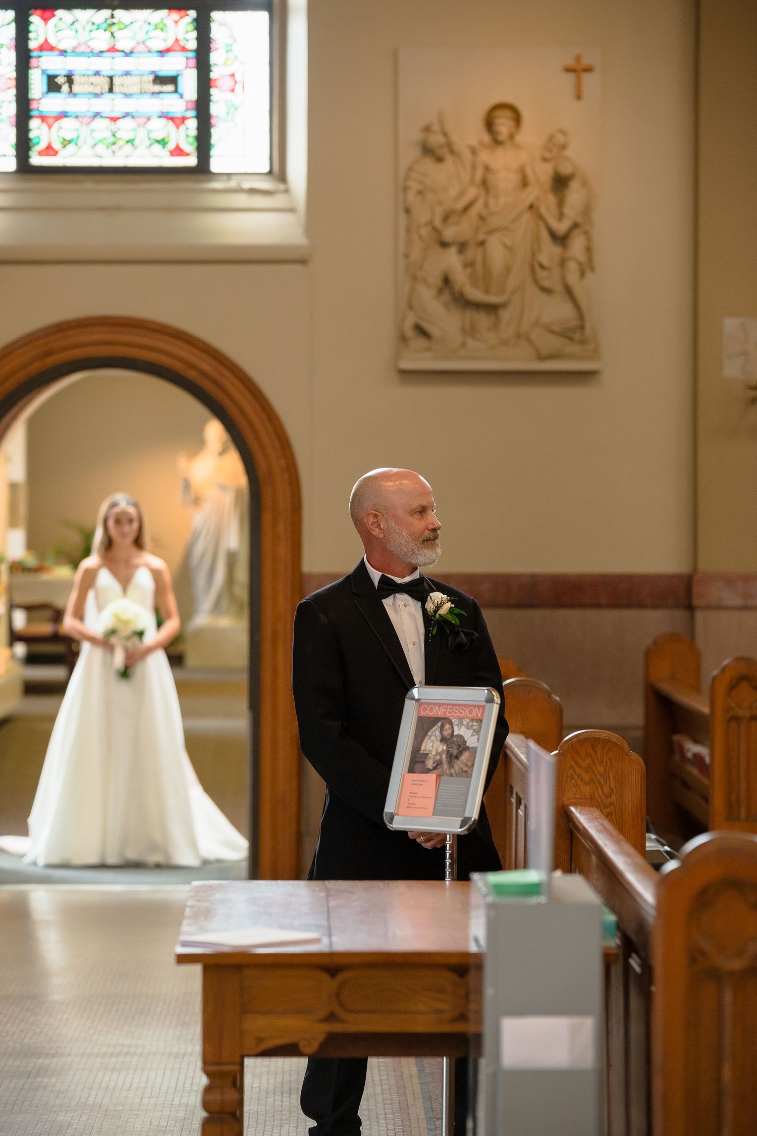 Traditional church wedding ceremony with guests seated in wooden pews.