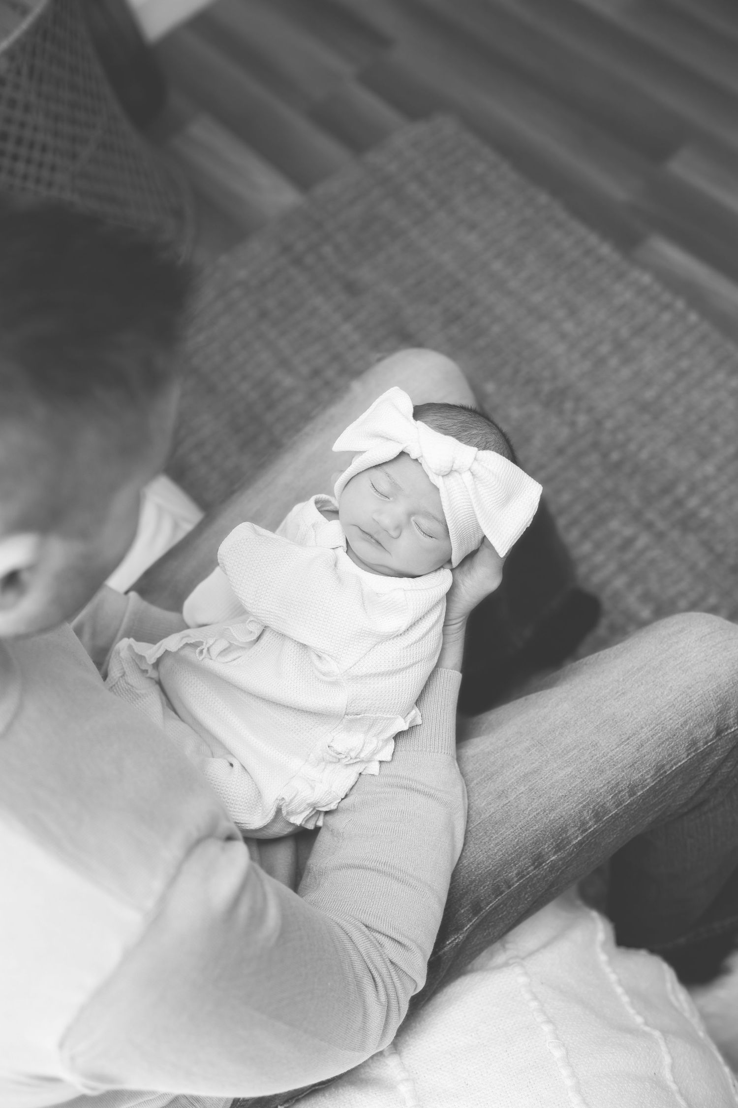 Black and white close-up of sleeping newborn wrapped in soft blanket.