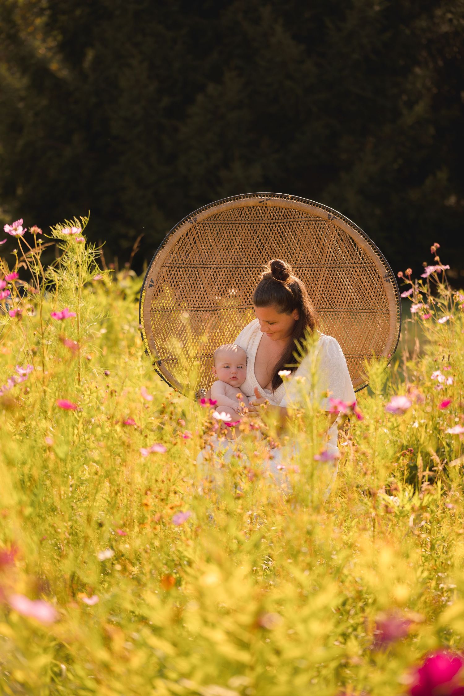Wicker chairs among wildflowers at sunset creating dreamy outdoor scene.