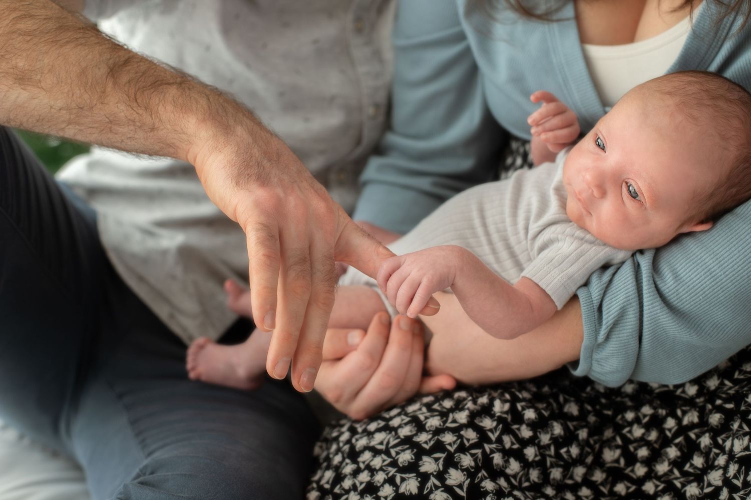 Cropped series showing gentle hands cradling a small infant.
