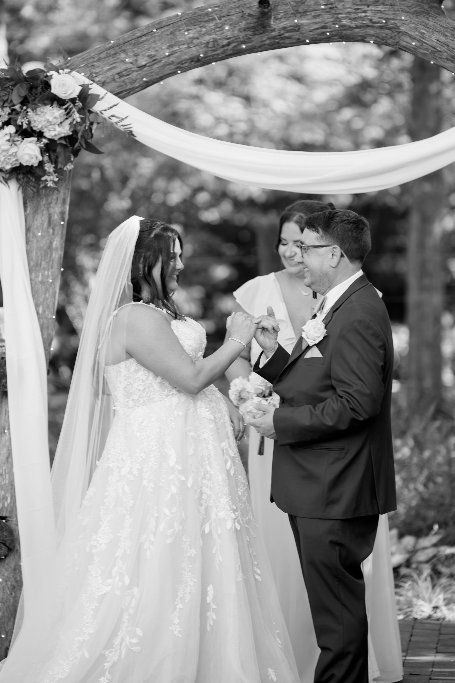 Black and white photo of couple sharing emotional moment during wedding ceremony.