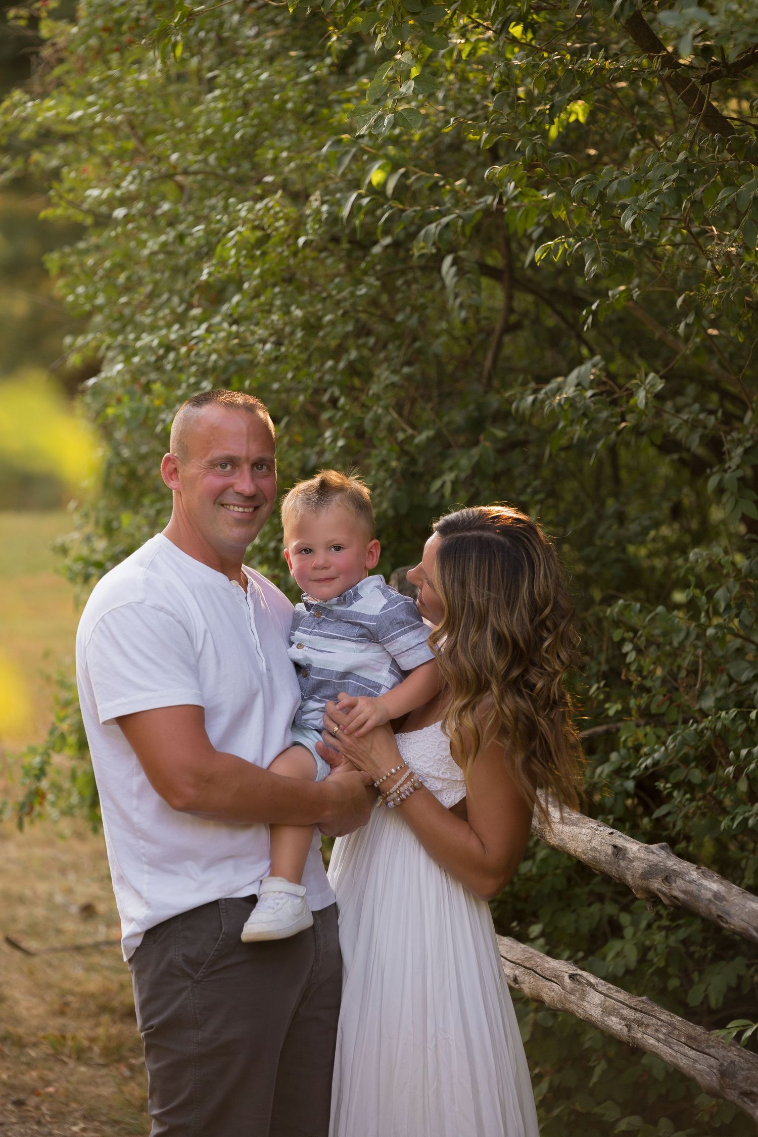 Sweet family interactions captured in a natural outdoor setting with lush greenery.