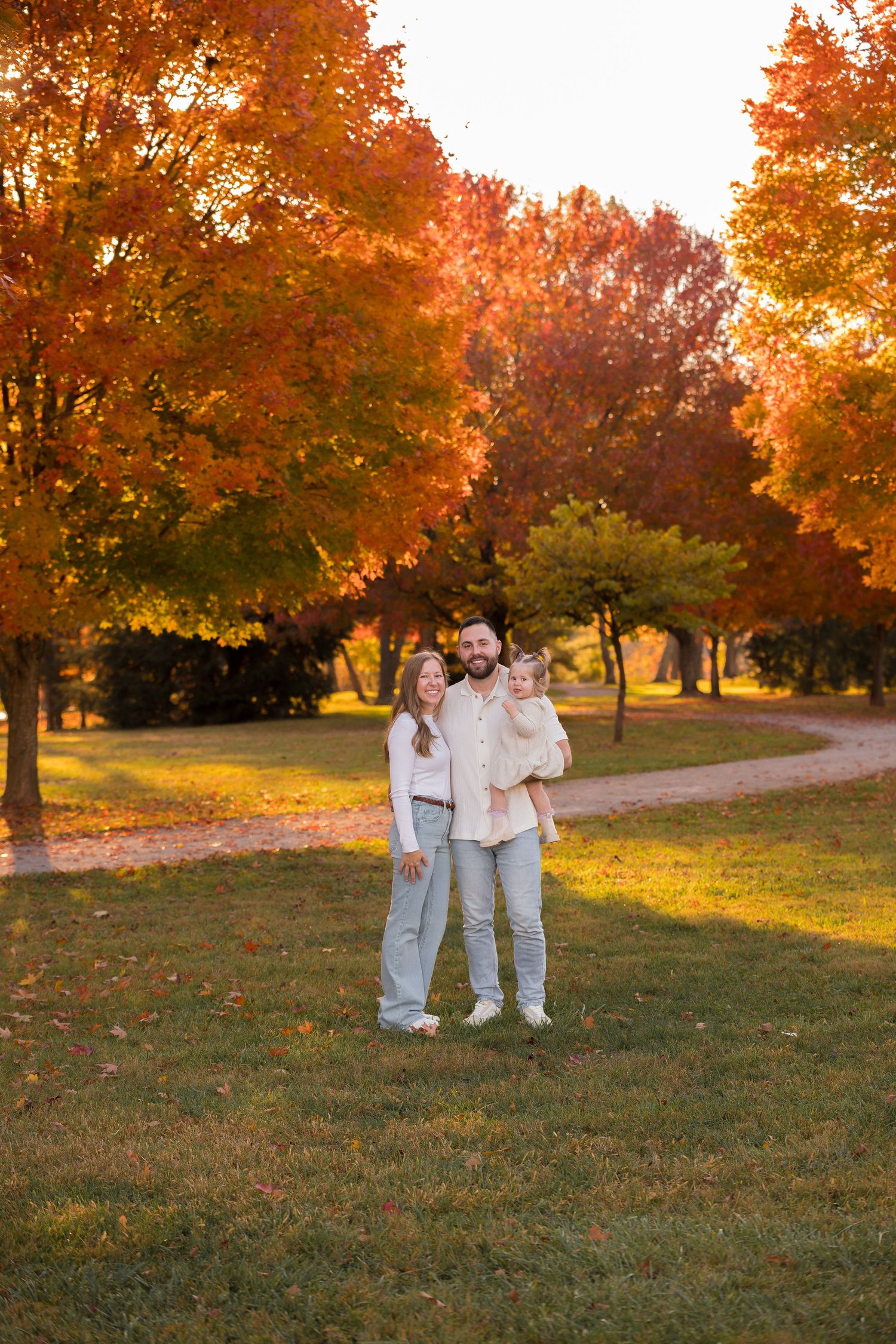 A group enjoys autumn scenery with vibrant orange foliage in a park setting.