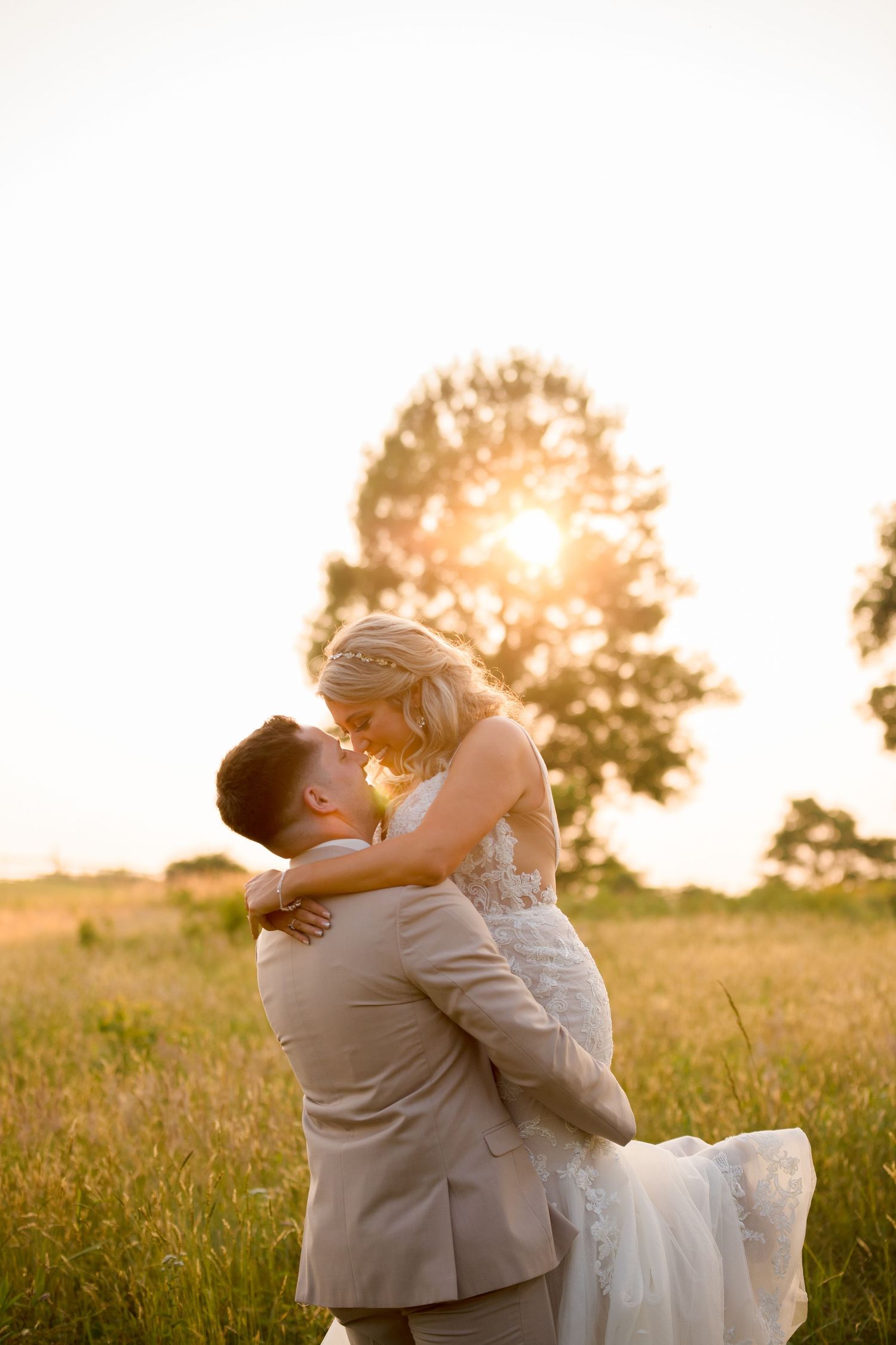 Sunset wedding portrait with dramatic lighting in a golden field.